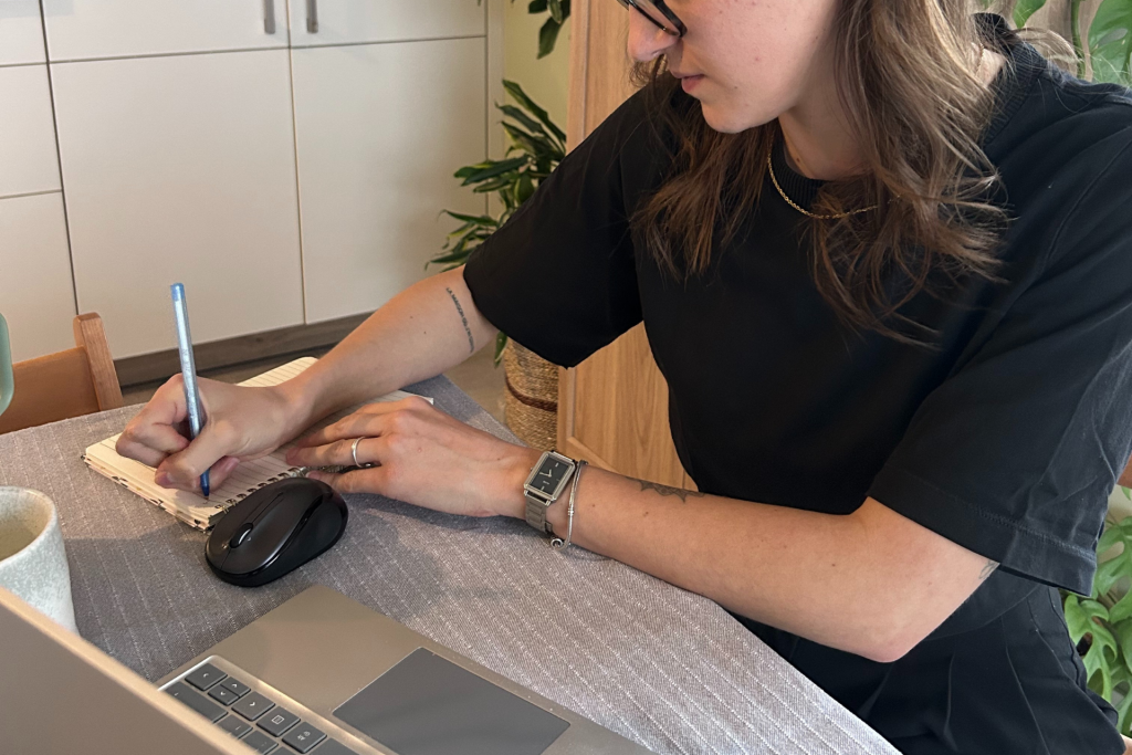 Une femme travaille au bureau et écrit dans son carnet