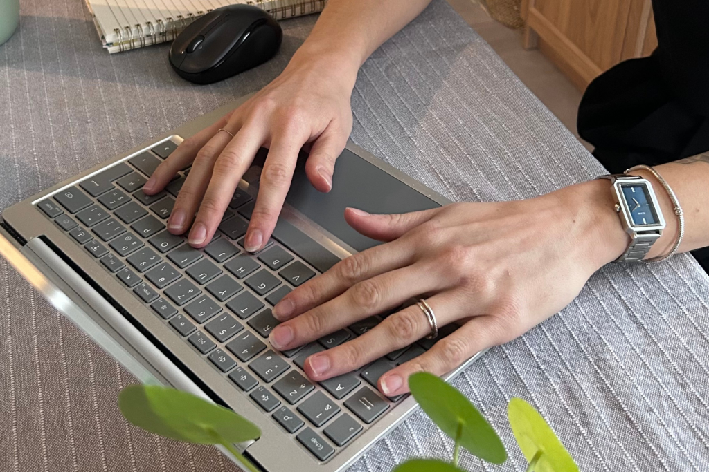 Une femme tape sur son clavier d'ordinateur portable